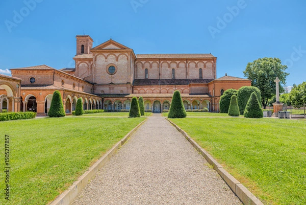 Fototapeta Saint Christopher Church of the Charterhouse of Ferrara, featuring a beautiful cloister and lush lawn, stands as a significant monument in the city on a sunny day under a clear blue sky