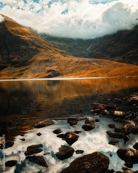 Fototapeta Calm waters of Lough Callee reflect the majestic mountains and clouds above during twilight. The serene landscape showcases the beauty of Ireland's natural scenery.