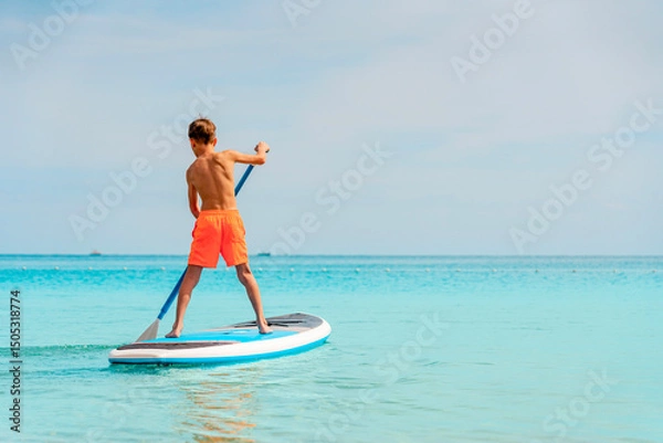 Fototapeta Photo from Hurghada in Egypt of boy on paddleboard