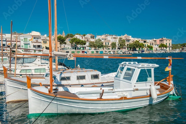 Fototapeta Traditional boats in the harbor of Portocolom with the old town in the background - 3104