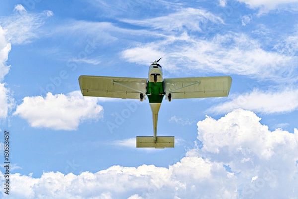 Obraz Single engine ultralight plane flying in the blue sky with white clouds	