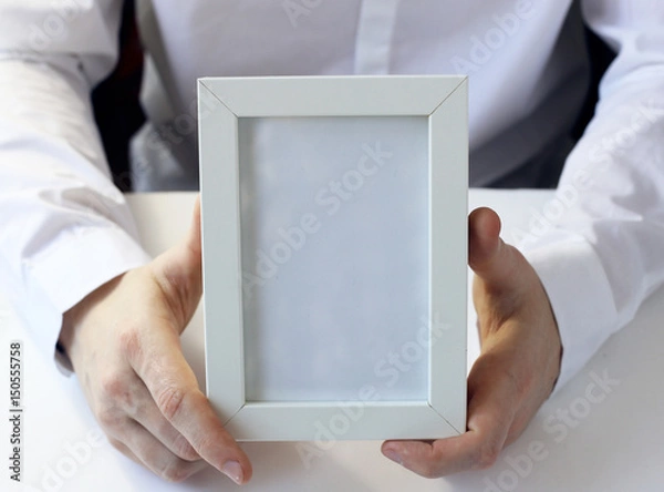 Obraz White photo frame in hands.