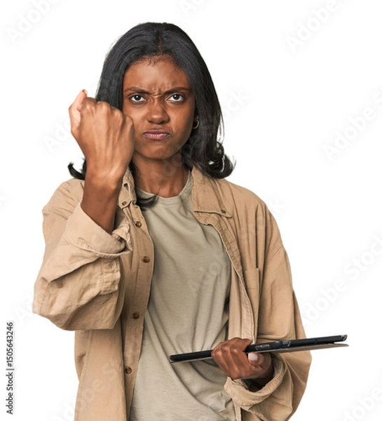 Fototapeta Young Indian woman with digital tablet showing fist to camera, aggressive facial expression.