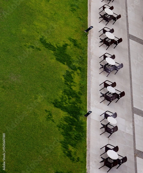 Obraz outdoor cafe tables from abow and green grass, vertical
