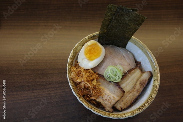Fototapeta A delicious bowl of Japanese ramen featuring rich broth, tender sliced pork, a perfectly soft-boiled egg with runny yolk, fresh scallions, and crispy nori seaweed. 