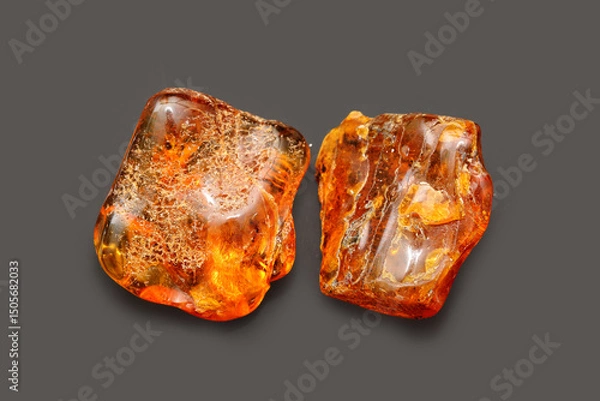 Fototapeta Amber with patterns and light on the black background. Sun stone. Fossil fossilized resin. Semi-precious mineral. Natural material for jewelry. Copal. Science.  Polished amber stone.
