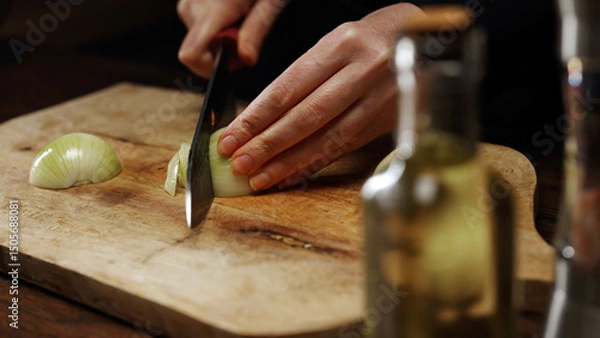 Obraz Female Chef Slicing Onion on Wooden Cutting Board.