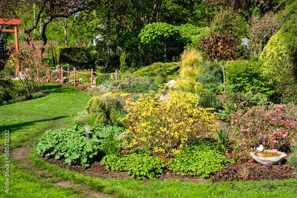 Obraz A vibrant, well-maintained ornamental Lush Flower Garden with Decorative Rock and Mulch. Ideal image for themes related to landscaping, gardening, backyard design, and nature aesthetics.