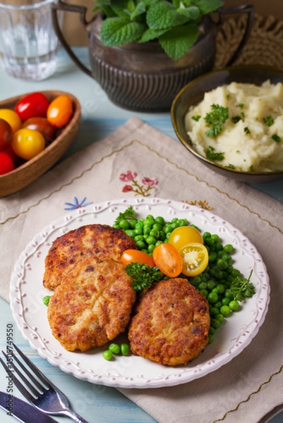 Fototapeta Fish cakes with green peas. Fish patties or burgers. View from above, top studio shot