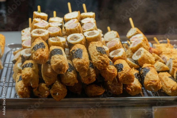 Fototapeta Korean street food skewers, close-up, assorted fried and rolled fish cakes with seaweed, appetizing and fresh display at Seoul, South Korea, Myeongdong Market