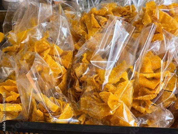 Obraz Fried Wontons, golden yellow, crispy, delicious, packed in clear bag for sale. Deep Fried Wonton Wrapped With Seasoned Minced Pork. Serve with sweet chili sauces. Snacks packed in bags for consumption
