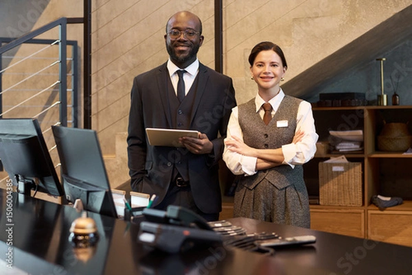Fototapeta Friendly hotel staff in formal attire greeting guests at reception desk Embracing hospitality with warm smiles and professional demeanor, ready to assist guests