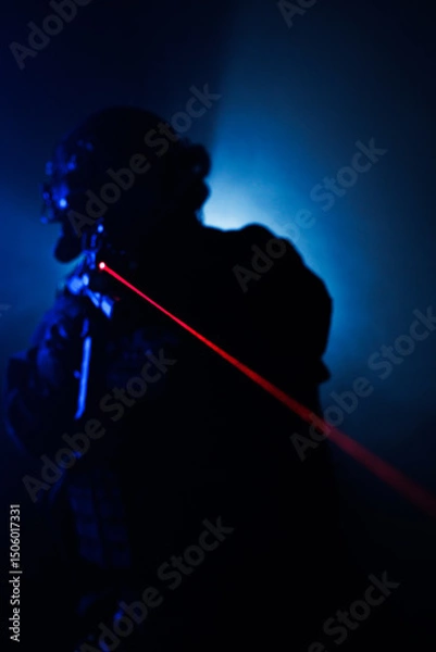 Fototapeta Tactical figure with red laser beam in dramatic low light setting