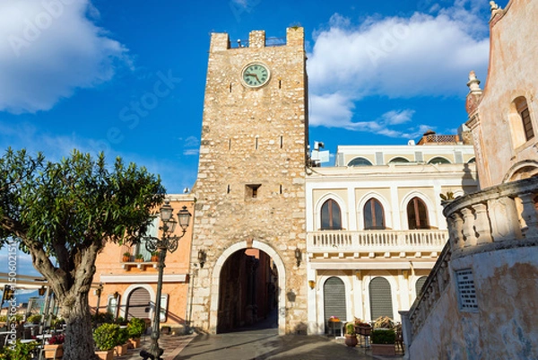 Obraz Historic stone clock tower located on Piazza IX Aprile in Taormina, Sicily, Italy. Popular tourist attraction in Taormina with scenic views, traditional buildings and Mediterranean architecture.