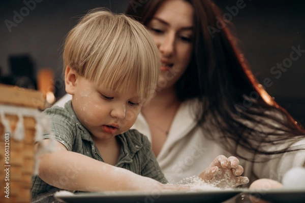 Fototapeta Early childhood moment of gentle parenting as mother and son playfully explore flour and creativity at the kitchen table during messy play that celebrates home rituals and everyday connection