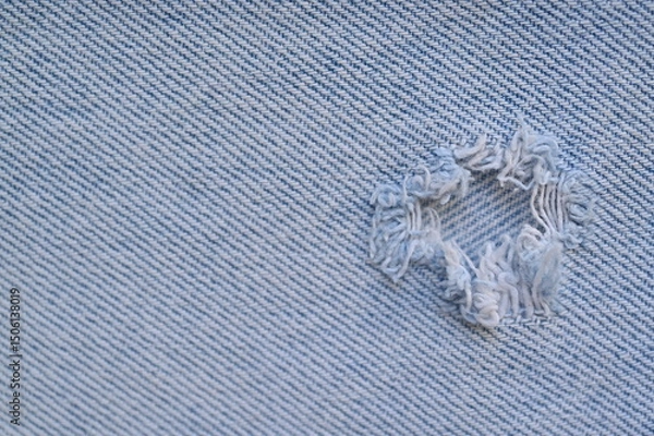 Fototapeta torn light grey denim surface, denim fringe , hole macro texture of blue denim, torn blue denim texture as background photo close up from above	

