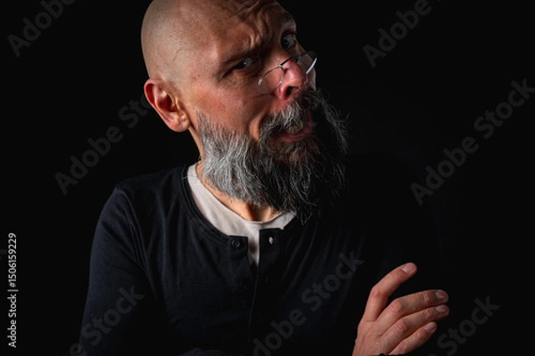 Obraz Funny close-up portrait of a quirky bald man with a long gray beard and eyeglasses, making a silly face. Concept of eccentricity, humor, and expressive personality.