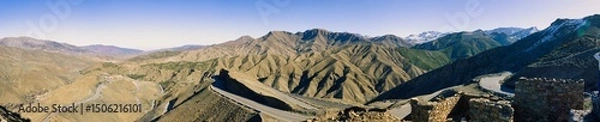 Fototapeta Arid mountain valley with village and road.