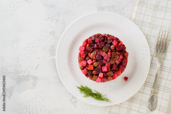 Fototapeta Salad vinaigrette on a plate on a white background. Top view.