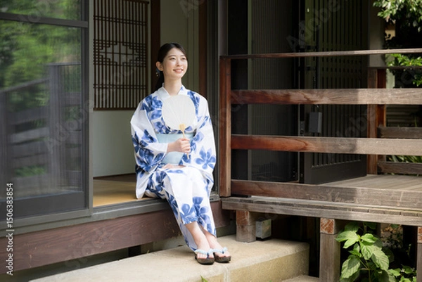 Fototapeta Woman in yukata relaxing on the porch of an old house Looking up at the view Image