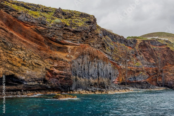 Fototapeta Dramatic geological formations along a rugged coastline with ocean views, showing volcanic layers, erosion textures and natural detail.