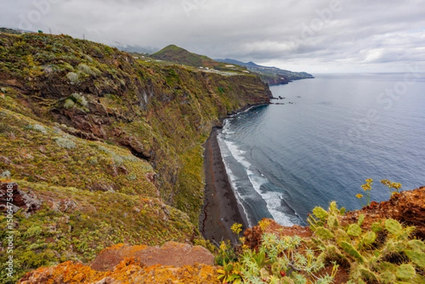 Fototapeta Dramatic geological formations along a rugged coastline with ocean views, showing volcanic layers, erosion textures and natural detail.
