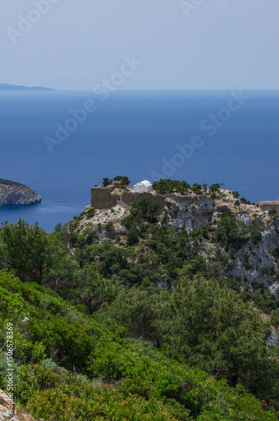 Fototapeta Monolithos Castle on top of a mountain with a white chapel and a view of the Aegean Sea vertical orientation (Rhodes, Greece)