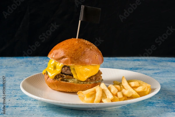 Fototapeta Smash burger with cheddar cheese and caramelized onions, served with fries