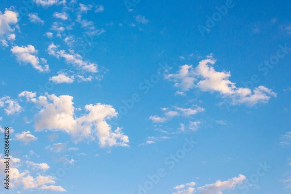 Fototapeta blue sky with clouds on a sunny august morning. climate change. fluffy formations in bright weather. blue nature backdrop in morning light. warm forecast background