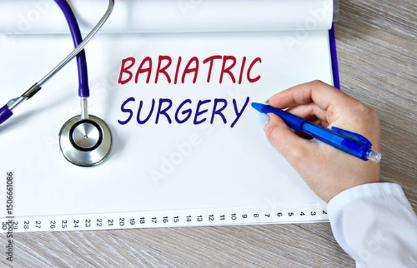 Fototapeta BARIATRIC SURGERY - words in a notebook against the background of a stethoscope and a doctor's hand with a pen