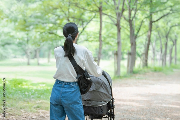 Fototapeta ベビーカーを押して公園を散歩する母親