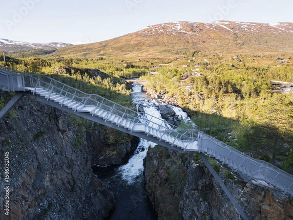 Fototapeta Famous stepped bridge over the turbulent Voringsfossen waterfall – a breathtaking tourist attraction in the picturesque mountains of Norway.