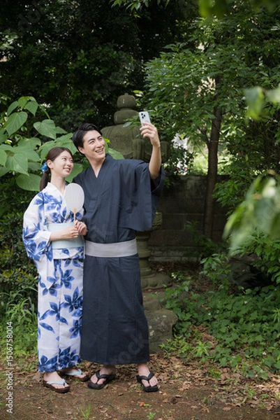 Fototapeta 浴衣でスマホを持つ自撮りするカップル　観光や旅行などのイメージ　全身