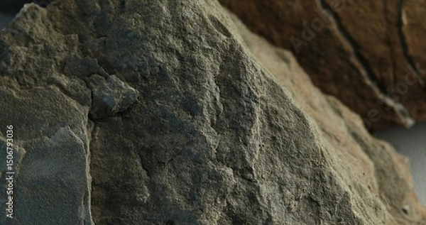 Fototapeta Close-up of rough gray rock with uneven surface and side lighting