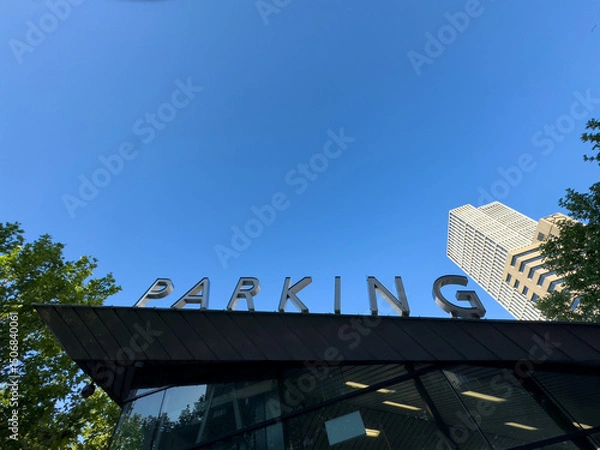Obraz PARKING sign on the roof. Metallic letters text on blue sky background