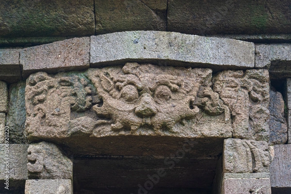 Obraz View of fierce Kala aka Kirtimukha face on lintel of ancient hindu Gedong Songo V temple door, Bandungan, Semarang, Java, Indonesia