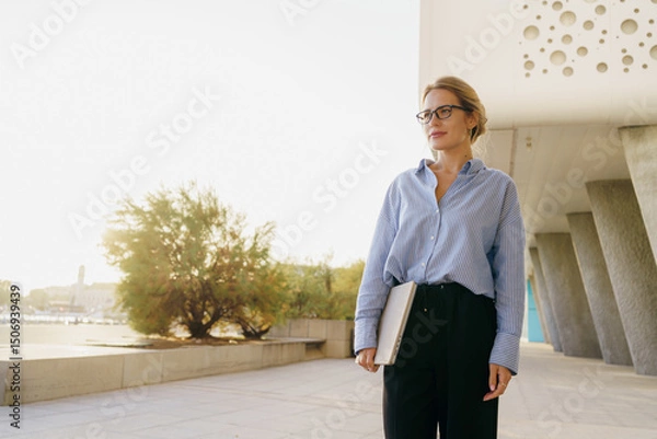 Obraz A Confident Professional Woman in a Modern Architectural Setting, Exuding Achievement