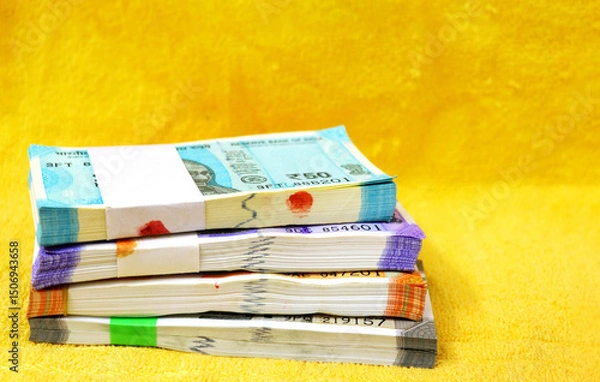 Fototapeta Indian currency Bundles of 50, 100, 200 or 500 rupee notes arranged in a row