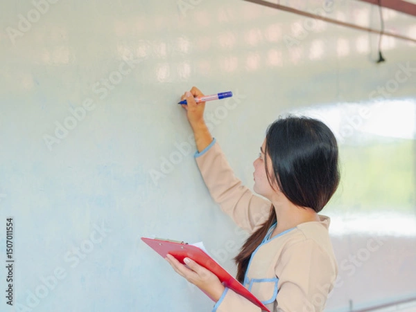 Fototapeta Chinese student teacher enjoys using pen to write on whiteboard for teaching children in kids school. Asian school and teacher. Teacher teaching students learning in classroom. Education knowledge 