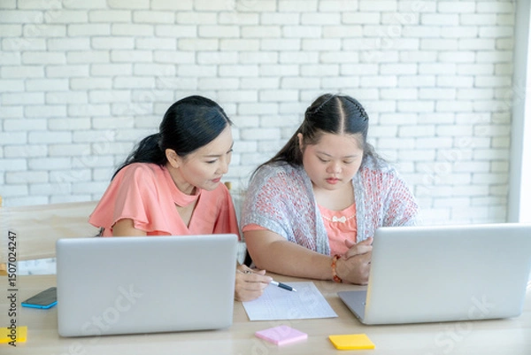 Fototapeta Caring mother guiding her young daughter in using the internet properly on a computer, family learning and online safety concept