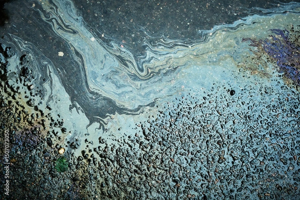 Fototapeta Colorful oil slick forming captivating patterns on the asphalt surface, glistening from recent rain.
