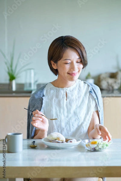 Fototapeta 部屋で朝食を食べる女性