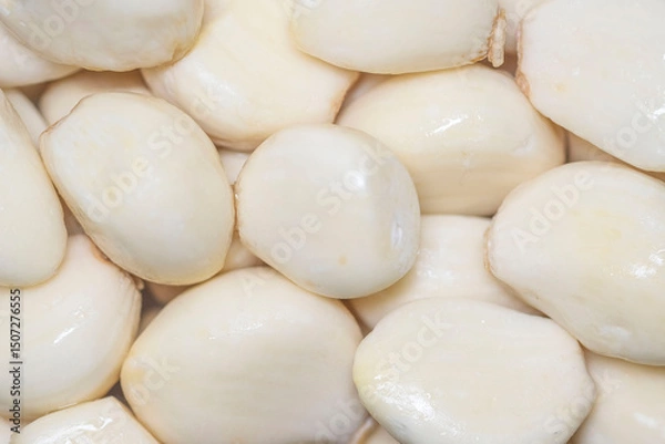 Fototapeta Close-up of stacked peeled garlic cloves. Square format.