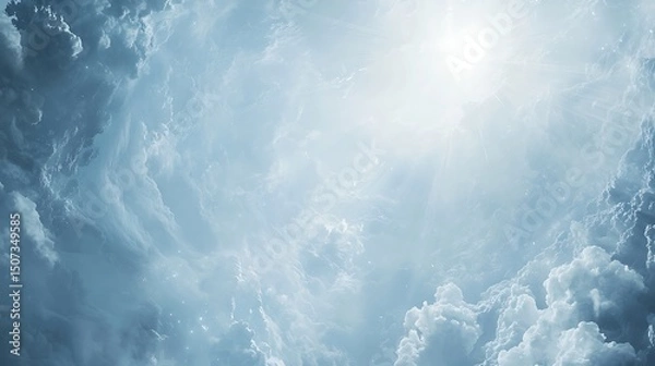 Obraz Fluffy white clouds floating in a pale blue sky, with sun rays softly shining through, creating a serene and dreamy atmosphere.
