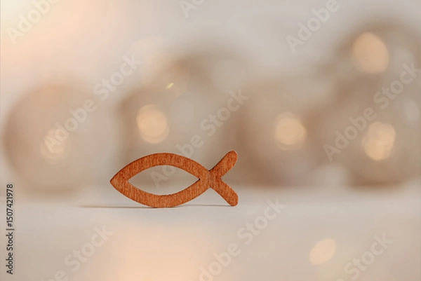 Fototapeta Kommunion, Konfirmation, Taufe - kleiner Fisch aus Holz auf neutralen Hintergrund mit Lichtern