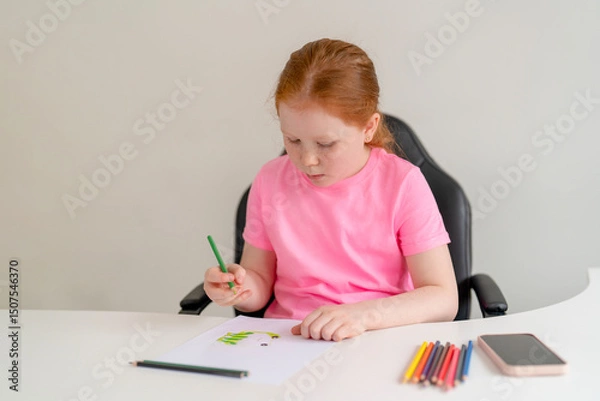 Obraz Girl focuses on drawing with colored pencils at a white desk in a bright room during a calm afternoon