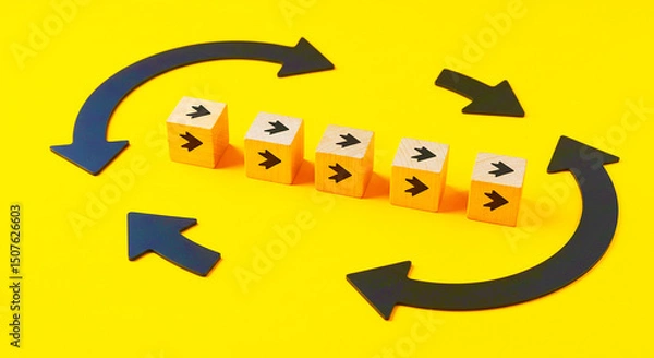 Fototapeta A conceptual image showing wooden blocks with arrows and circular arrows on a yellow background