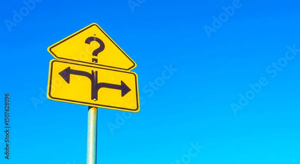 Fototapeta A yellow sign with a question mark and arrows pointing left and right against a blue sky outdoor view