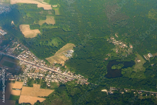 Obraz Wide aerial view of rural town and dense forest. Useful for illustrating land use, geography, or environmental studies.