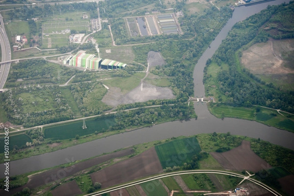 Obraz Wide aerial landscape showing industrial building and river. Useful for environmental, infrastructure, or land use context.